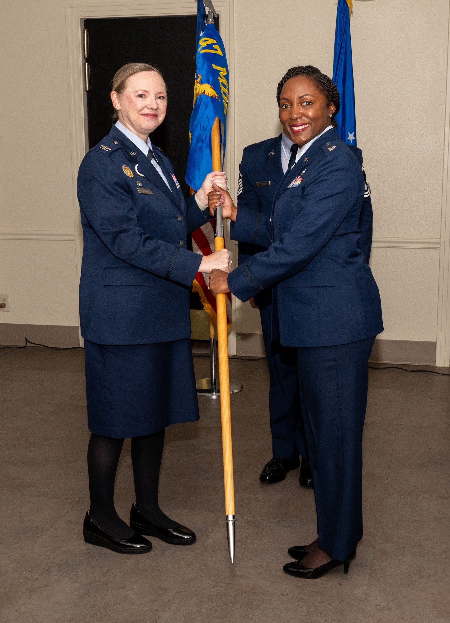 U.S. Air Force Col. Angela Lacek, 47th Medical Group commander, presents the 47th Operational Medical Readiness Squadron (OMRS) guidon to Lt. Col. Avis McCaslin, 47th OMRS commander, during the 47th OMRS change of command ceremony at Laughlin Air Force Base, Texas, June 21, 2024. Change of command ceremonies represent a formal transfer of authority and responsibility for a unit from one commanding officer to another. (U.S. Air Force photo by Staff Sgt. Nicholas Larsen)