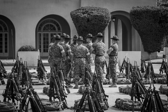 U.S. Marine Corps drill instructors engage in conversation at Marine Corps Recruit Depot San Diego, California, June 6, 2024. Drill instructors have trained and molded over one million Marines in San Diego since the early 1920s. (U.S. Marine Corps photo illustration by Cpl. Elliott A. Flood-Johnson)