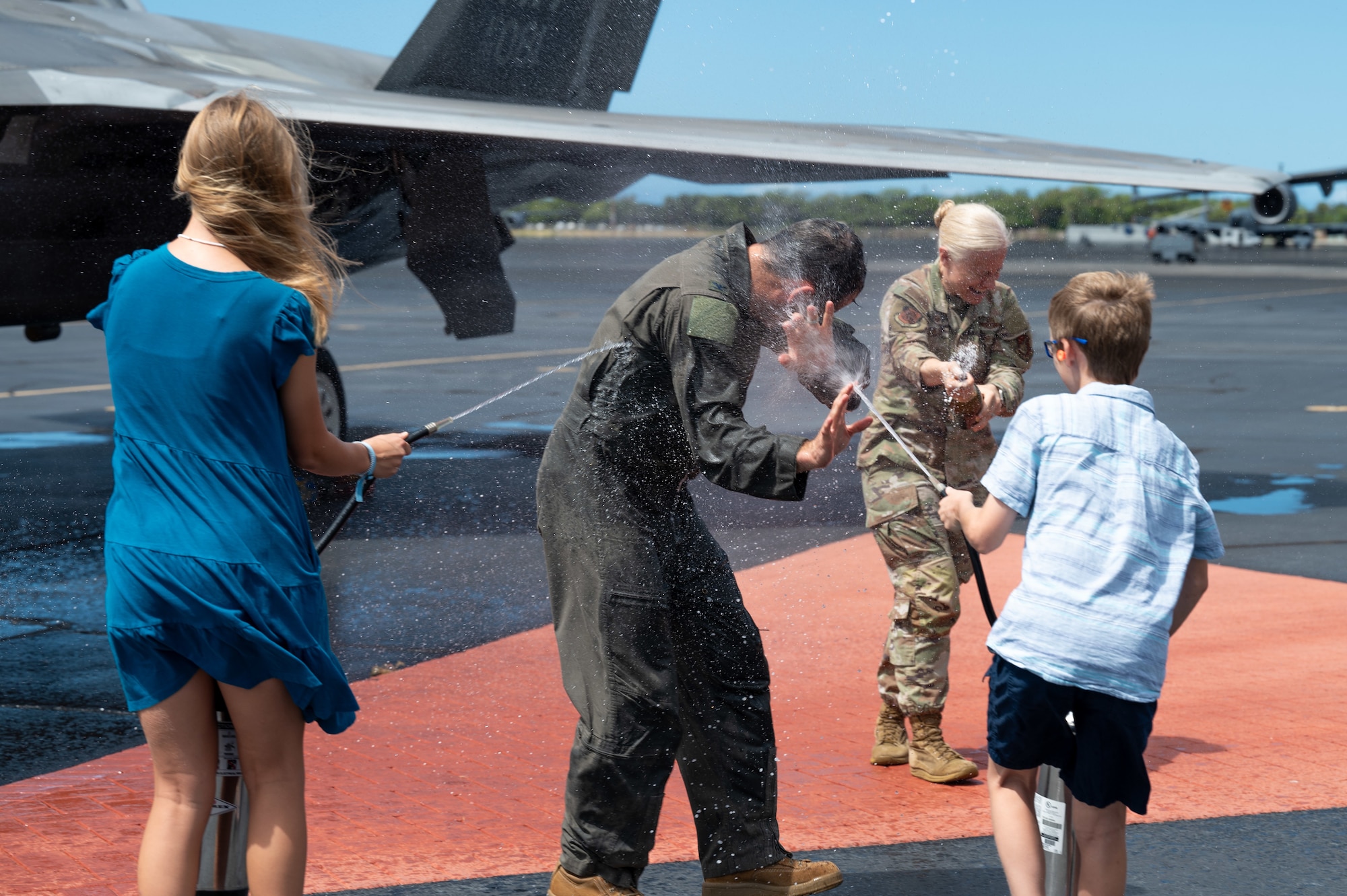 Airmen are sprayed with water.