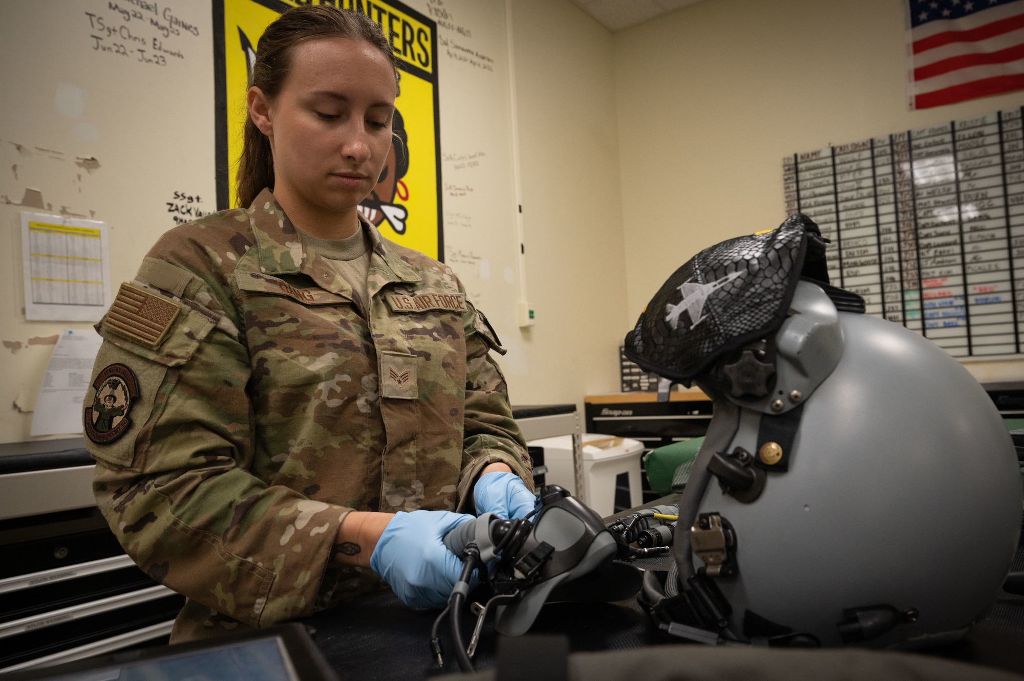 Senior Airman Madison Gang, 8th Operations Support Squadron aircrew flight equipment journeyman, inspects a helmet.