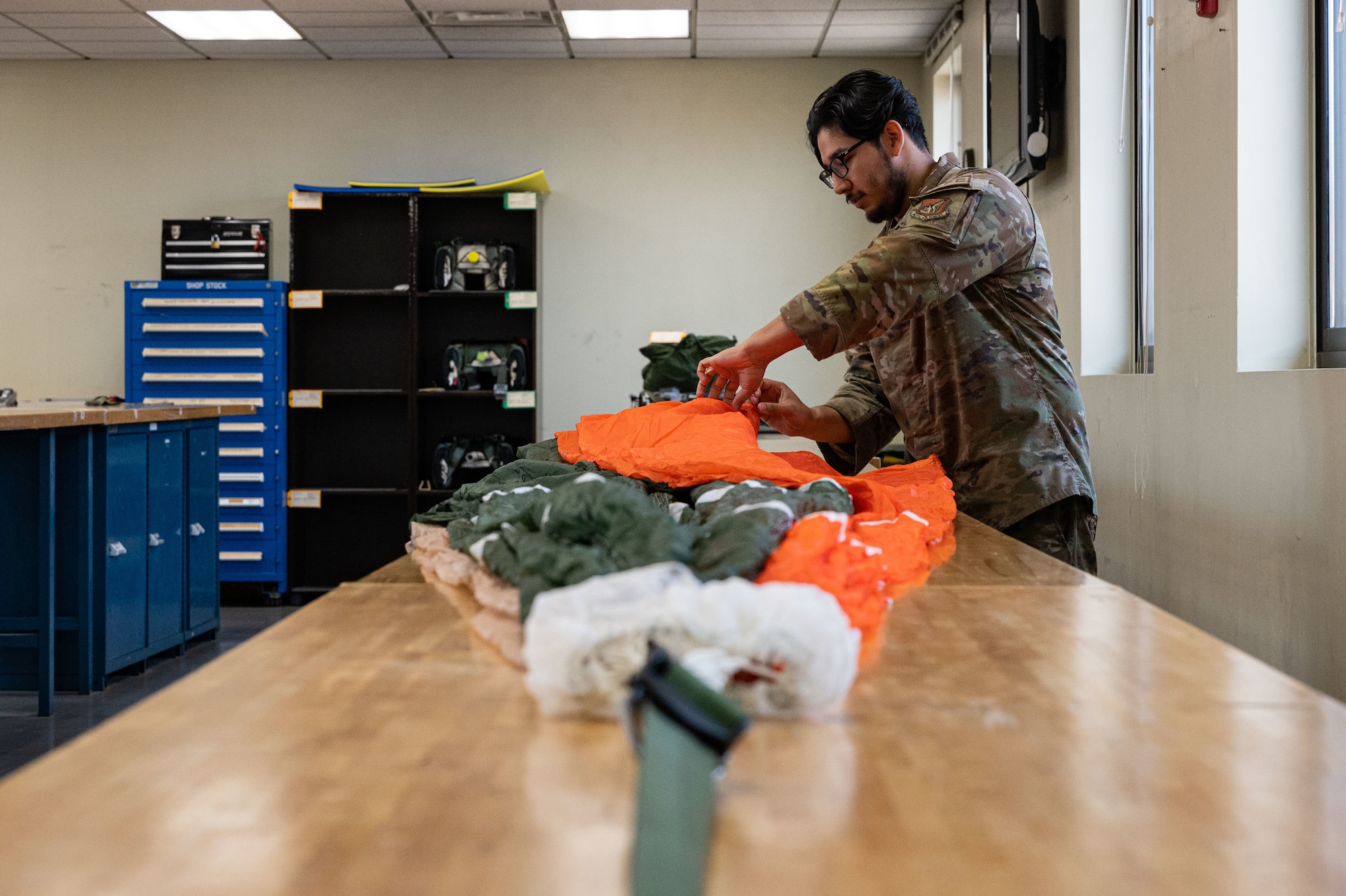 Senior Airman Alejandro Buentello, 8th Operations Support Squadron aircrew flight equipment technician, inspects a recovery parachute.