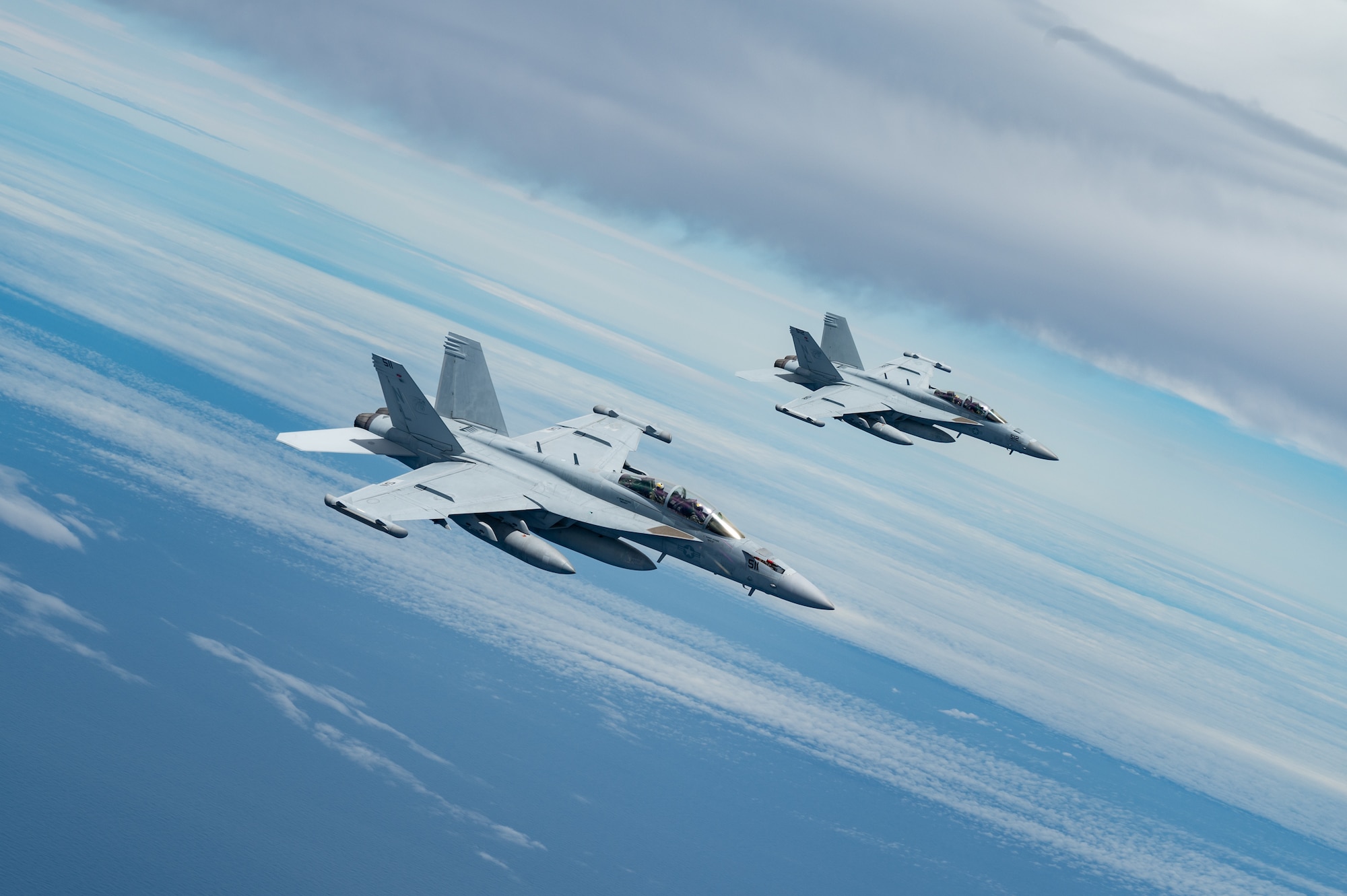 EA-18s fly in formation over the Pacific Ocean.