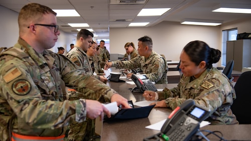 Servicemembers in a line in a building.