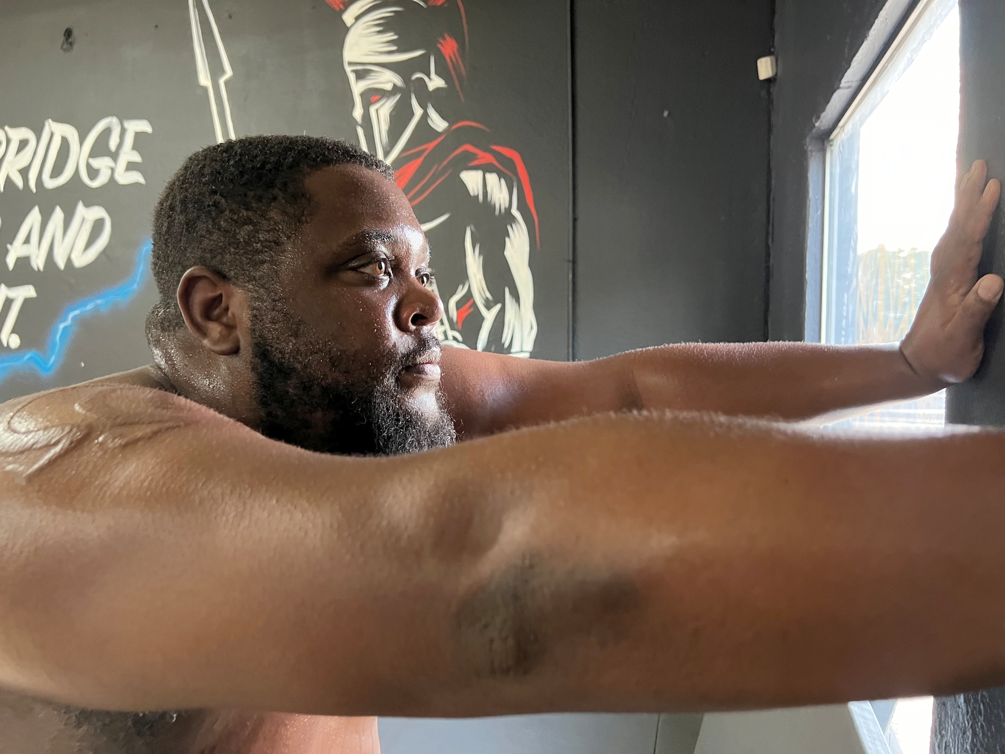 Closeup of Scriven with hands pushing against a wall