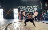 coming toward camera in squat position with arms bent in front of him