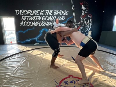 Scriven pictured at left grappling with his teammate while the stable's sensei looks on.