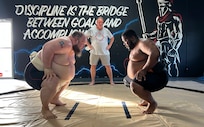 Scriven and Baccus in the squat position with hands on knees