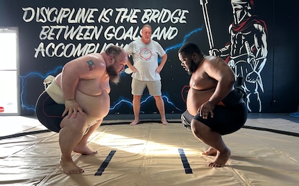 Scriven and Baccus in the squat position with hands on knees