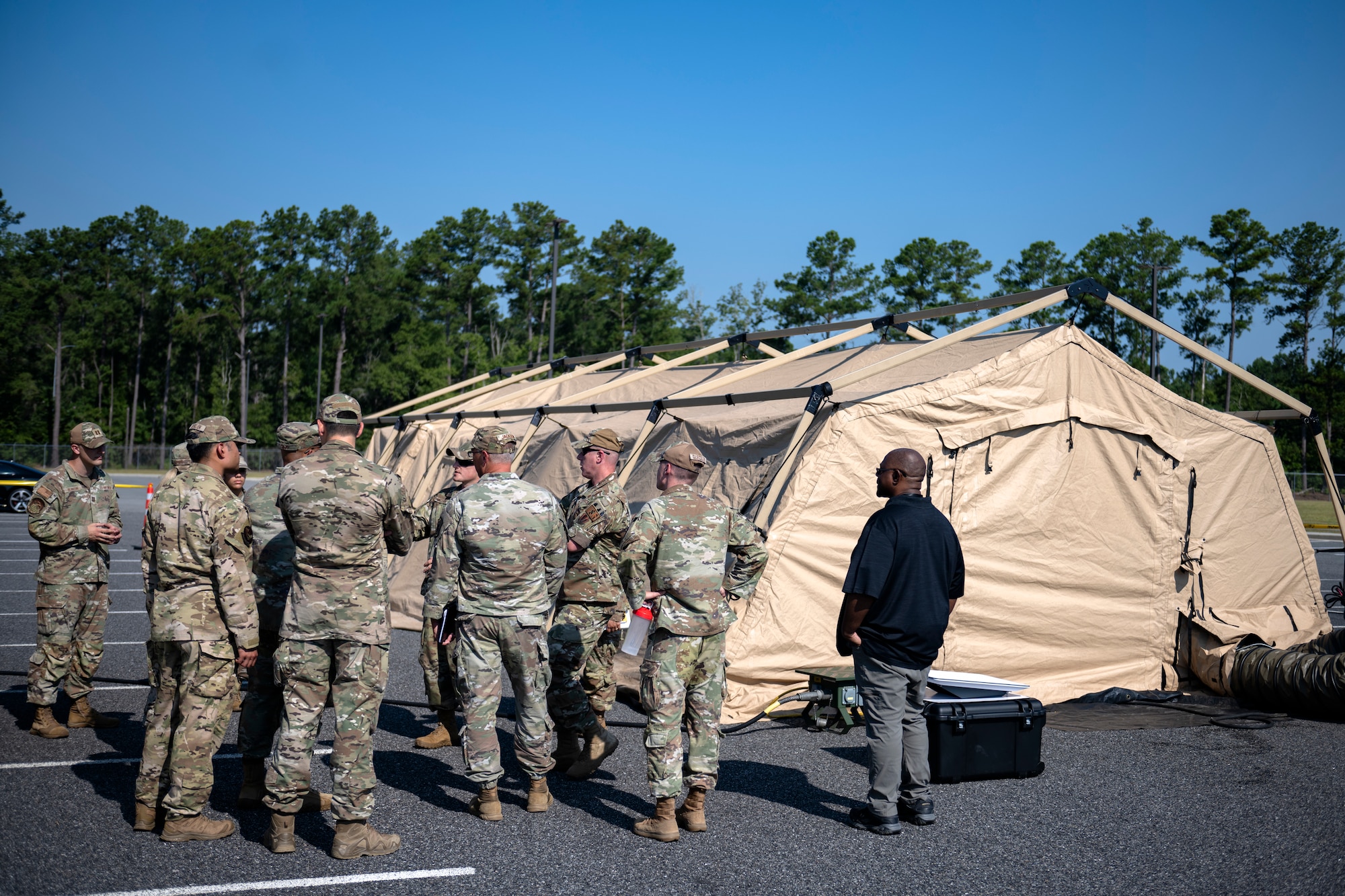 A group of people standing outside a military tent