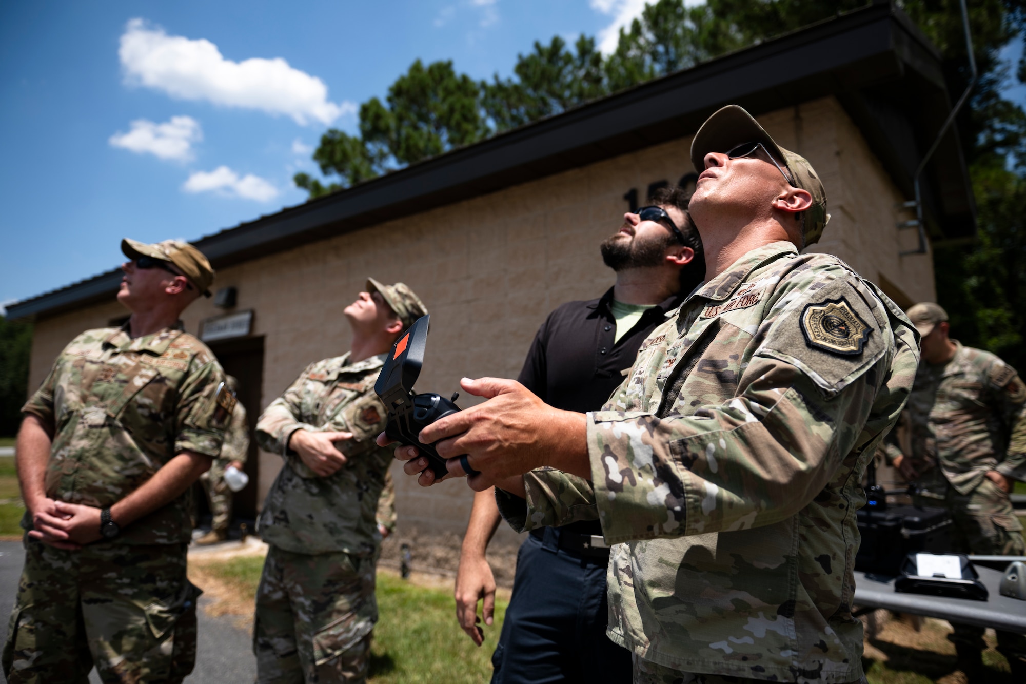 people standing in a group while one holds a drone controller