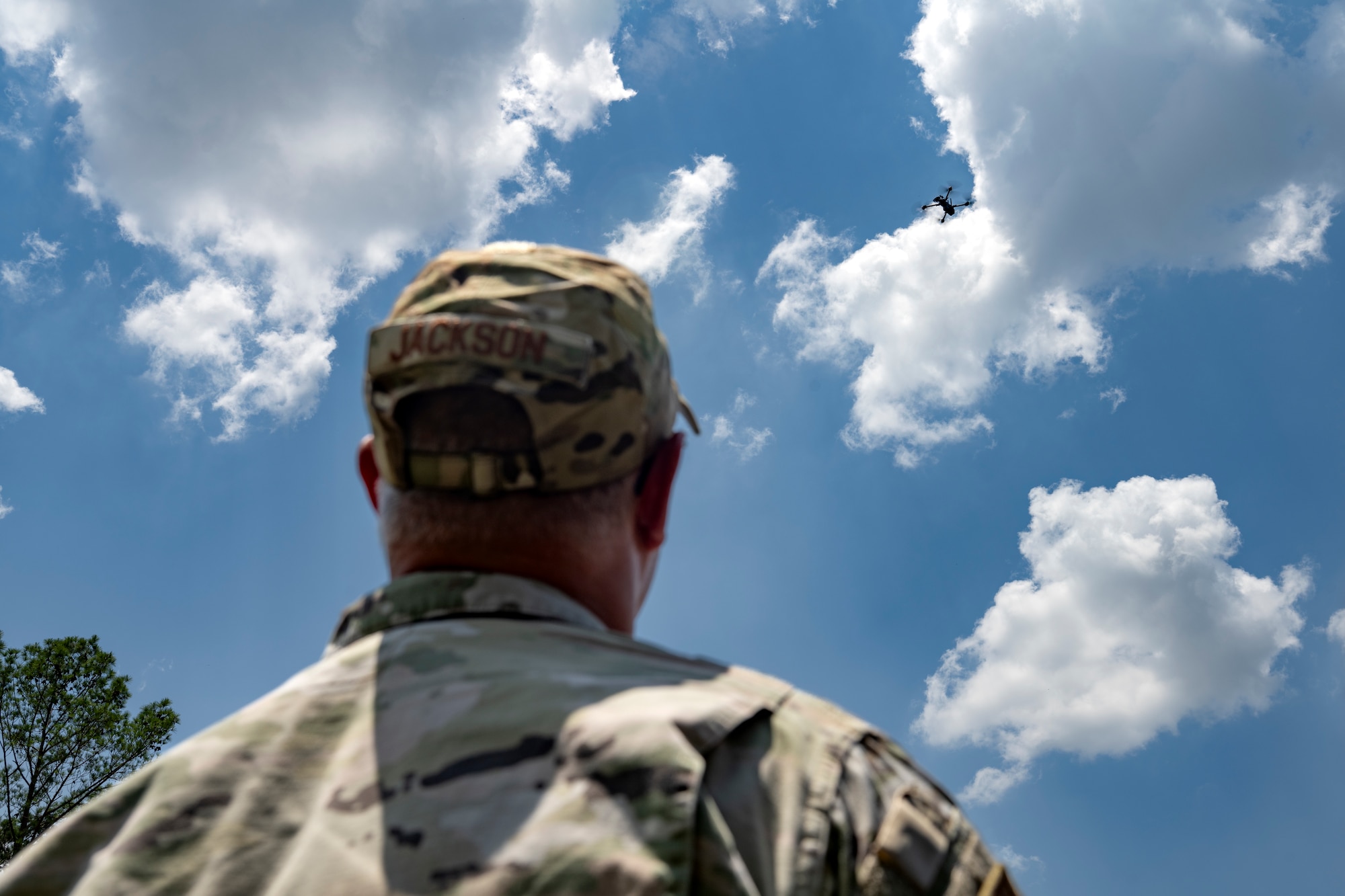 Person standing outside and a drone in the sky