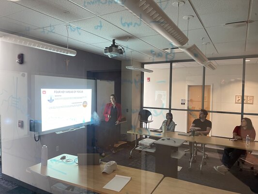 USACE employee gives career brief on working for Buffalo District with students from a university watching.