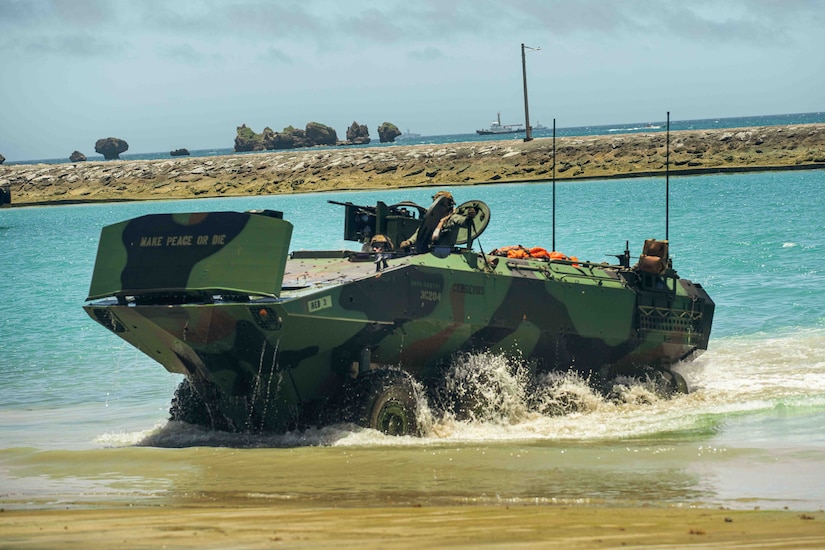 An amphibious combat vehicle moves onto a beach.