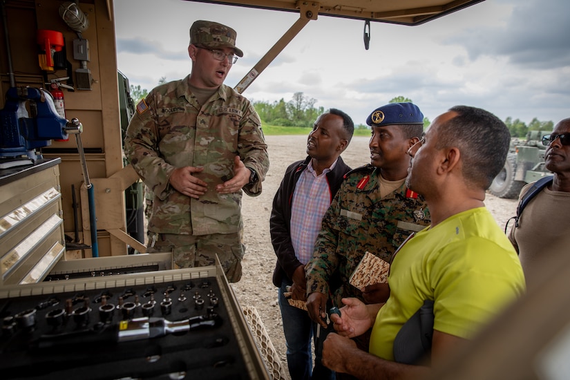 U.S. Army Sgt. Mark Dooley, the motor sergeant for the 2061st Multi-Role Bridge Company, explains the organization of maintenance contact trucks with engineer officers of the Djibouti Armed Forces (DAF) at Camp Dodge, Iowa on May 14, 2024. The DAF visited the Kentucky Army National Guard's 206th Engineer Battalion's annual training to learn ideas on how to set up battalion level engineer operations. (U.S. Army National Guard photo by Sgt. 1st Class Andrew Dickson)