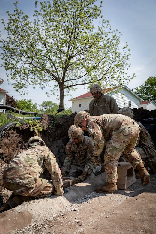 Engineers with the 130th Engineer support Company, 206th Engineer Battalion, Kentucky National Guard, set the foundation blocks for a retaining wall at Camp Dodge, Iowa on May 15, 2024. The 206th Engineer Battalion worked on various construction projects at Camp Dodge for their annual training.  (U.S. Army National Guard photo by Sgt. 1st Class Andrew Dickson)