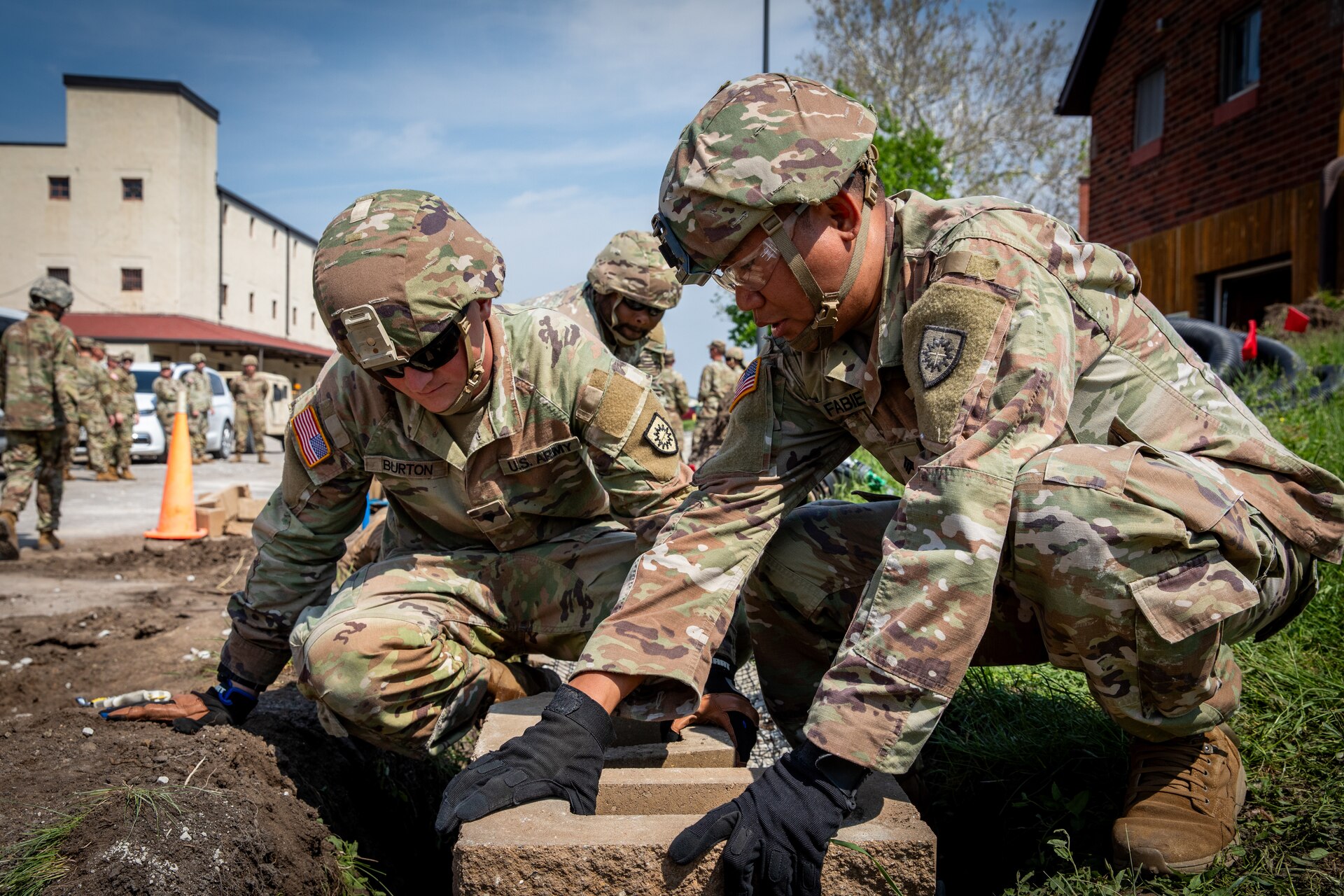 U.S. Army Spc. Christopher Burton and Sgt. Jerome Fabie, both construction engineers with the 130th Engineer Support Company, 206th Engineer Battalion, lay block for a retaining wall at Camp Dodge, Iowa on May 15, 2024. The 206th Engineer Battalion worked on various construction projects at Camp Dodge for their annual training.  (U.S. Army National Guard photo by Sgt. 1st Class Andrew Dickson)