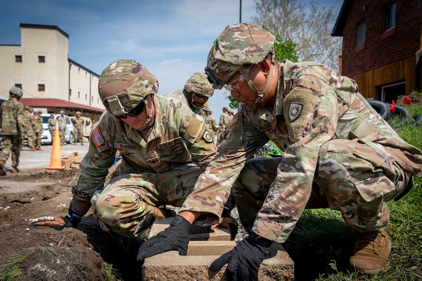 U.S. Army Spc. Christopher Burton and Sgt. Jerome Fabie, both construction engineers with the 130th Engineer Support Company, 206th Engineer Battalion, lay block for a retaining wall at Camp Dodge, Iowa on May 15, 2024. The 206th Engineer Battalion worked on various construction projects at Camp Dodge for their annual training.  (U.S. Army National Guard photo by Sgt. 1st Class Andrew Dickson)