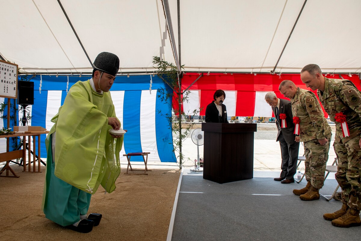 Participants bow their heads in respect as a Shinto priest performs a purification ritual