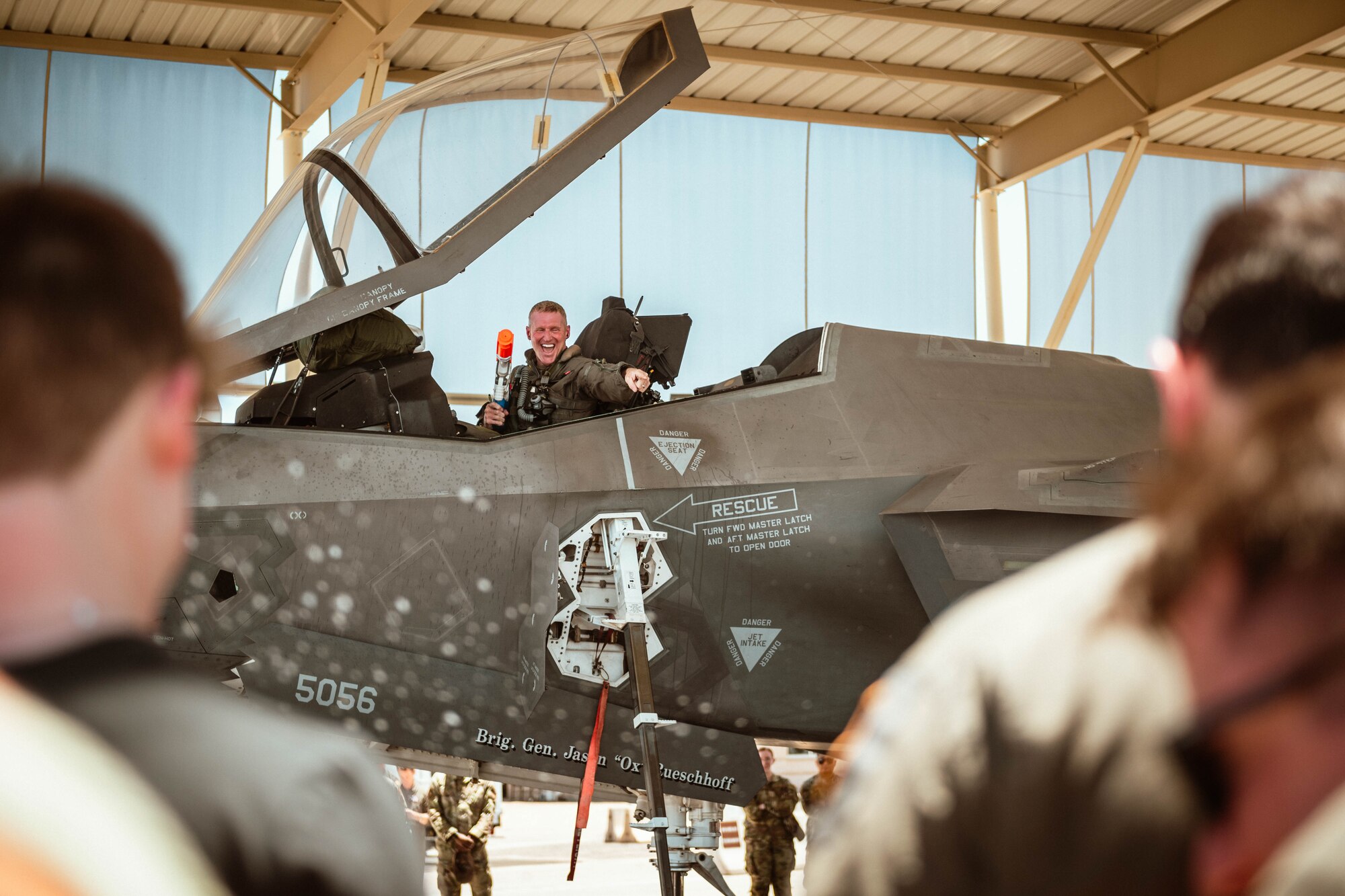 U.S. Air Force Brig. Gen. Jason Rueschhoff, 56th Fighter Wing commander, sprays people with a water gun from an F-35 Lightning II after his fini flight.