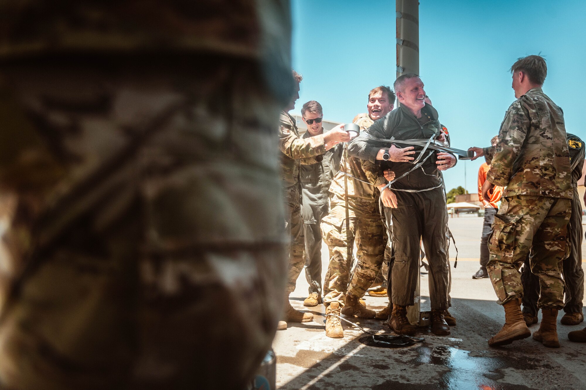 U.S. Air Force Brig. Gen. Jason Rueschhoff, 56th Fighter Wing commander, struggles out of the grasp of his fellow Airmen while they attempt to tie him up after his finial flight.