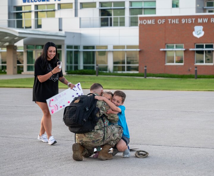 A U.S. Airman assigned to the 5th Bomb Wing reunites with family after returning from Bomber Task Force (BTF) 24-3 at Minot Air Force Base, North Dokata, June 26, 2024. U.S. Strategic Command BTF missions provide opportunities to train and work with allies and partners in joint and coalition operations and exercises. (U.S. Air Force photo by Airman 1st Class Luis Gomez)