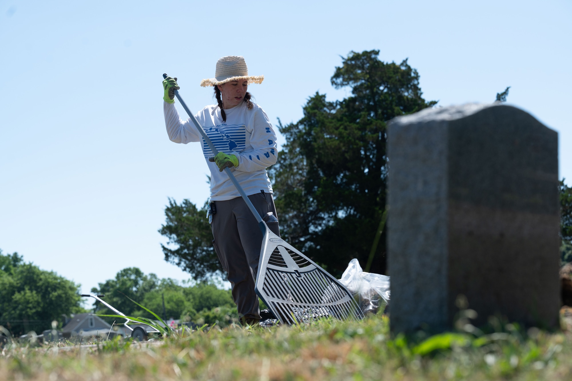 Airman stationed at JBLE rakes debris from headstones at the historic Pleasant Shade Cemetery