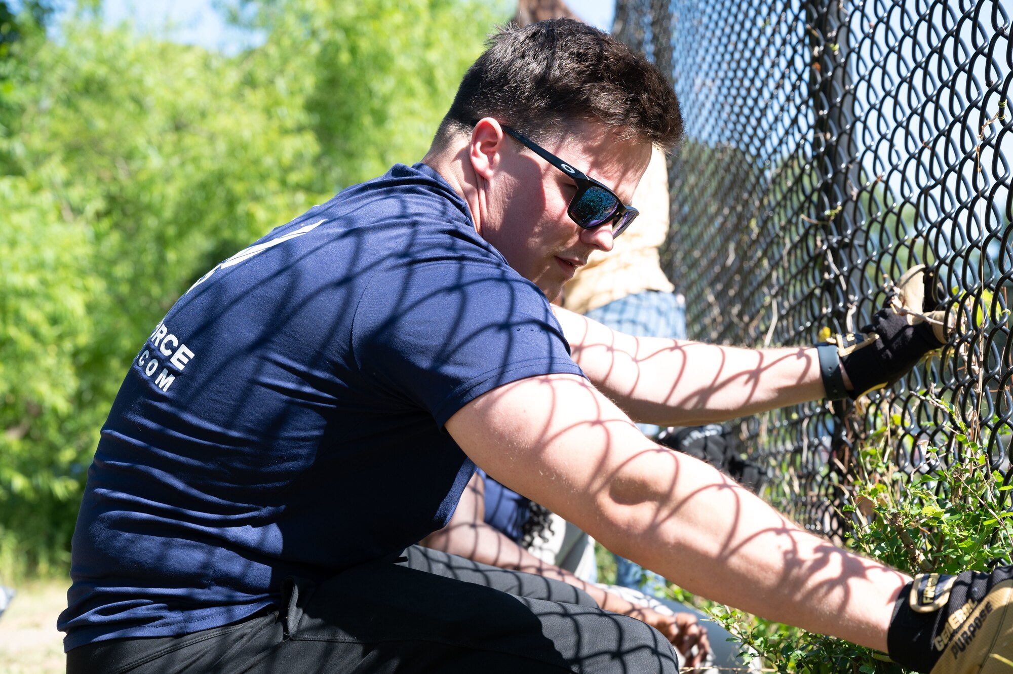 Airman stationed at JBLE pulls weeds at the Blue Bird Gap Farm
