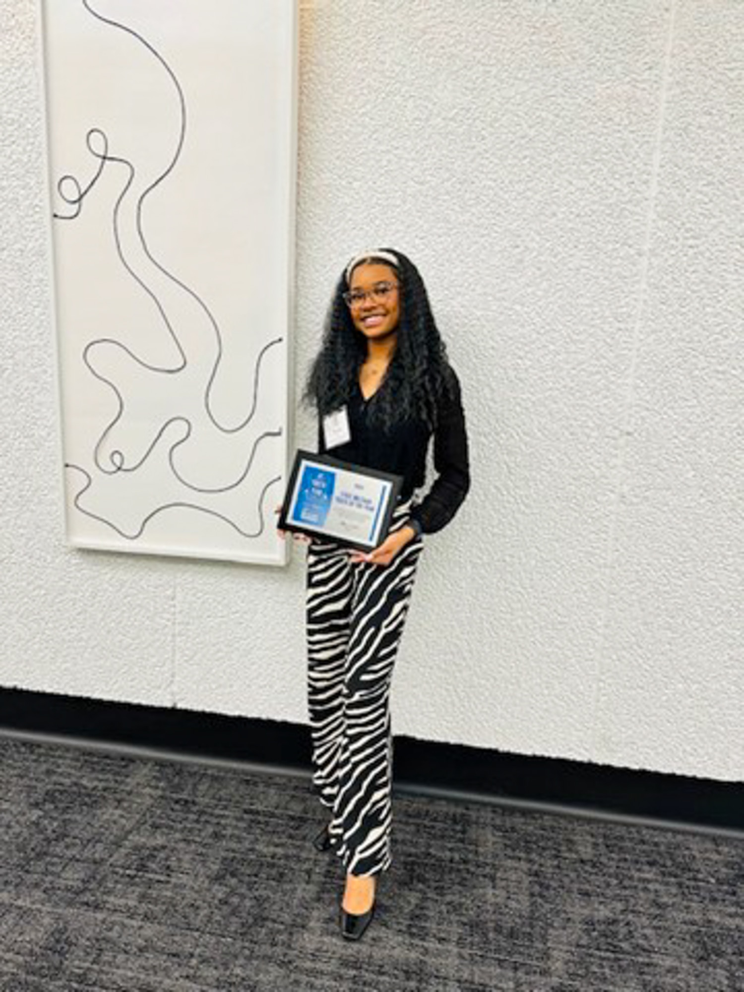 unday McGowan, daughter of LaParis McGowan, the 451st ESC Health Readiness Coordinator holds her award for becoming the Kansas Military Youth of the Year for 2024 at the Boys and Girls Clubs of America, Youth of the Year Award Ceremony in Topeka, Kansas, March 19. (Photo provided by Laparis McGowan)