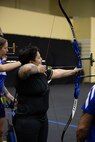 U.S. Army Spc. Berenice Carmona aims an arrow at her target during the archery event