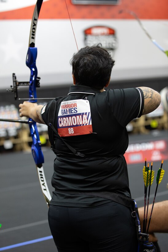 U.S. Army Spc. Berenice Carmona aims an arrow at her target during the archery event