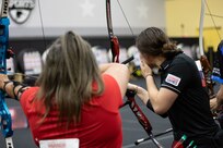 U.S. Army Sgt. Bianca Hayden, right, nocks an arrow during the archery event