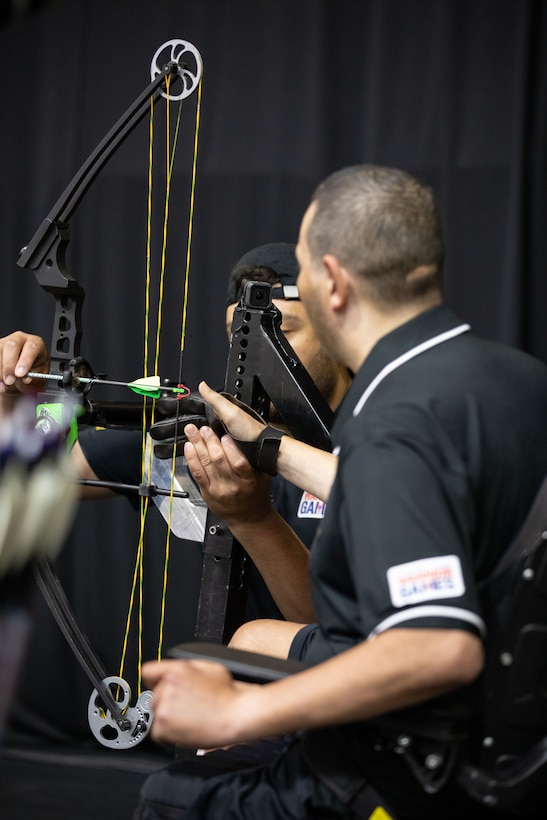 U.S. Army Cpt. Luis Avila and son Miguel Avila set up his bow