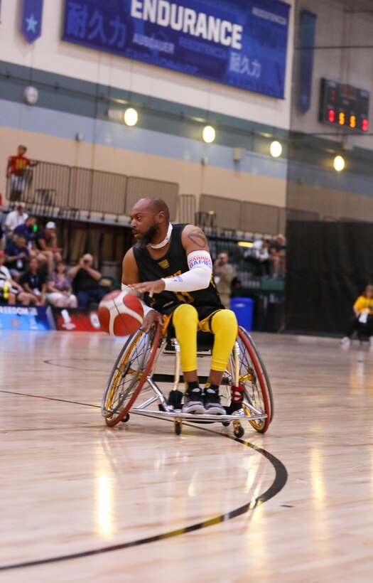 U.S. Army veteran Brent Garlic dribbles down court in a game of wheelchair basketball