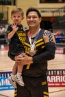 U.S. Army Cpt. Nathan Degan poses with his son after the team won the bronze medal in wheelchair rugby