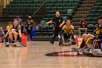 U.S. Army veteran Gerald Blakley, left, races down court with the ball in a wheelchair rugby match