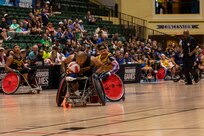 U.S. Army veteran Gene Calantoc races down court with the ball in a wheelchair rugby match