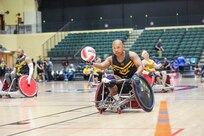 U.S. Army veteran Gene Calantoc races down court with the ball in a wheelchair rugby match