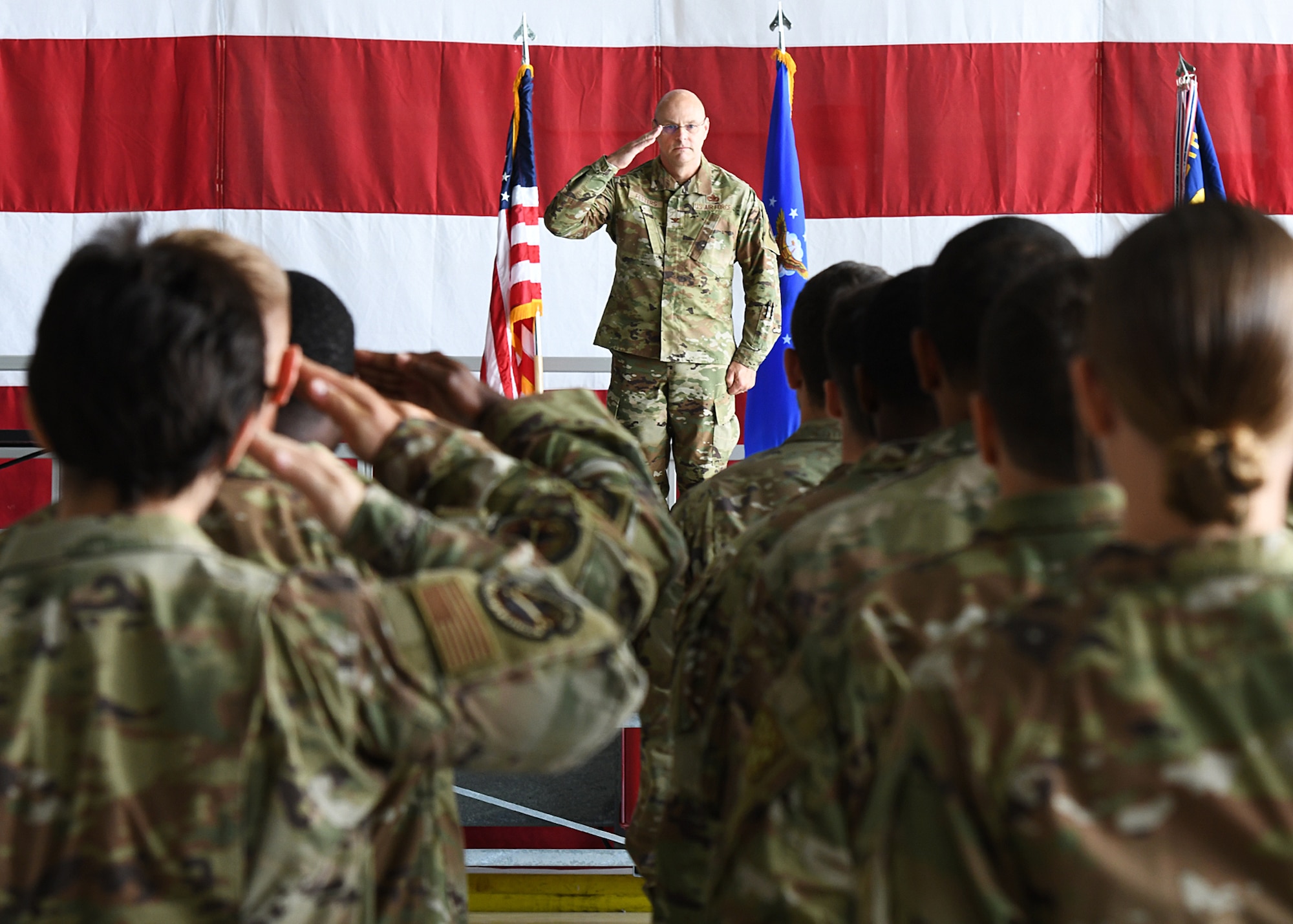 Airmen salutes a formation of his maintenance group members.