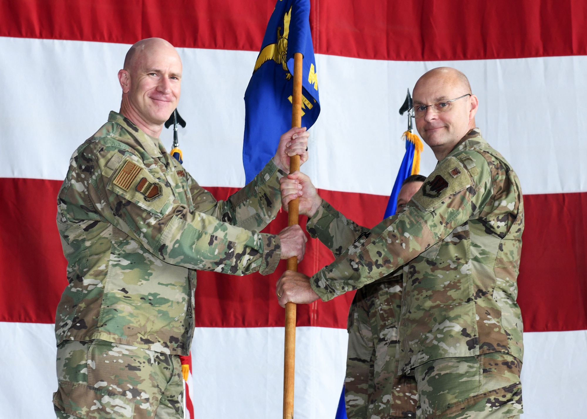 Airman passes guidon to airmen during change of command ceremony.