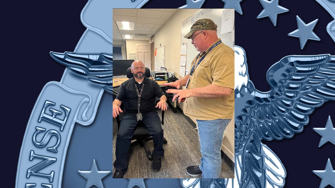 Man standing next to a man in chair
