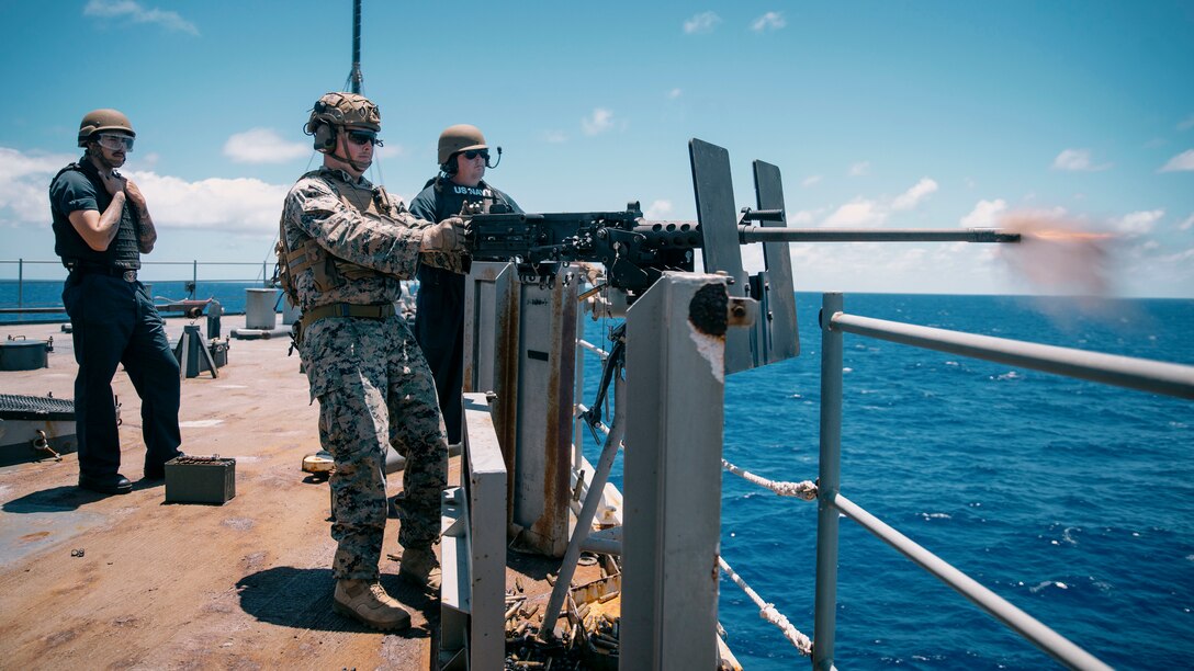 U.S. Marine Corps Cpl. Martin Stapleton, center left, a squad leader assigned to Bravo Company, Battalion Landing Team 1/5, 15th Marine Expeditionary Unit, and native of Massachusetts, fires a .50-caliber machine gun during a joint live-fire exercise aboard the Whidbey Island-class amphibious dock landing ship USS Germantown (LSD 42) while underway in the Pacific Ocean for Exercise Rim of the Pacific (RIMPAC) 2024, June 19, 2024. Twenty-nine nations, 40 surface ships, three submarines, 14 national land forces, more than 150 aircraft, and 25,000 personnel are participating in RIMPAC in and around the Hawaiian Islands, June 27 to Aug. 1. The world’s largest international maritime exercise, RIMPAC provides a unique training opportunity while fostering and sustaining cooperative relationships among participants critical to ensuring the safety of sea lanes and security on the world’s oceans. RIMPAC 2024 is the 29th exercise in the series that began in 1971. (U.S. Marine Corps photo by Cpl. Joseph Helms)