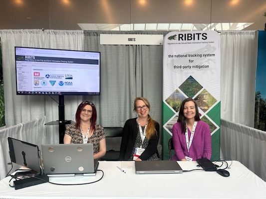 From left to right, Michelle Thompson, who manages the Help Desk, Shannon Langford, the lead Developer, and Valerie Layne, who manages RIBITS operations, pose for a photo on June 14, 2024 at the Environmental Markets Conference in Pittsburgh in May. The RIBITS team is set to push changes to the website on the 19th, which will result in a slightly different appearance. (Photo by Michelle Mattson)