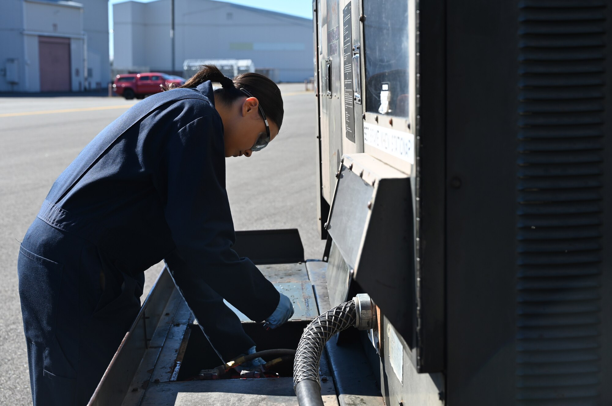 U.S. Air Force Airman 1st Class Viandra Santiago, an aerospace ground equipment journeyman with the 62d Maintenance Squadron, attaches battery cables to an 86-diesel generator to perform a load test at Joint Base Lewis-McChord, Washington, June 25, 2024. AGE Airmen perform load tests to ensure power supply to the aircraft during maintenance. These Airmen play a crucial role in guaranteeing the readiness and operational efficiency of the aircraft by maintaining and servicing essential ground support equipment. (U.S. Air Force photo by Airmen 1st Class Kylee Tyus)