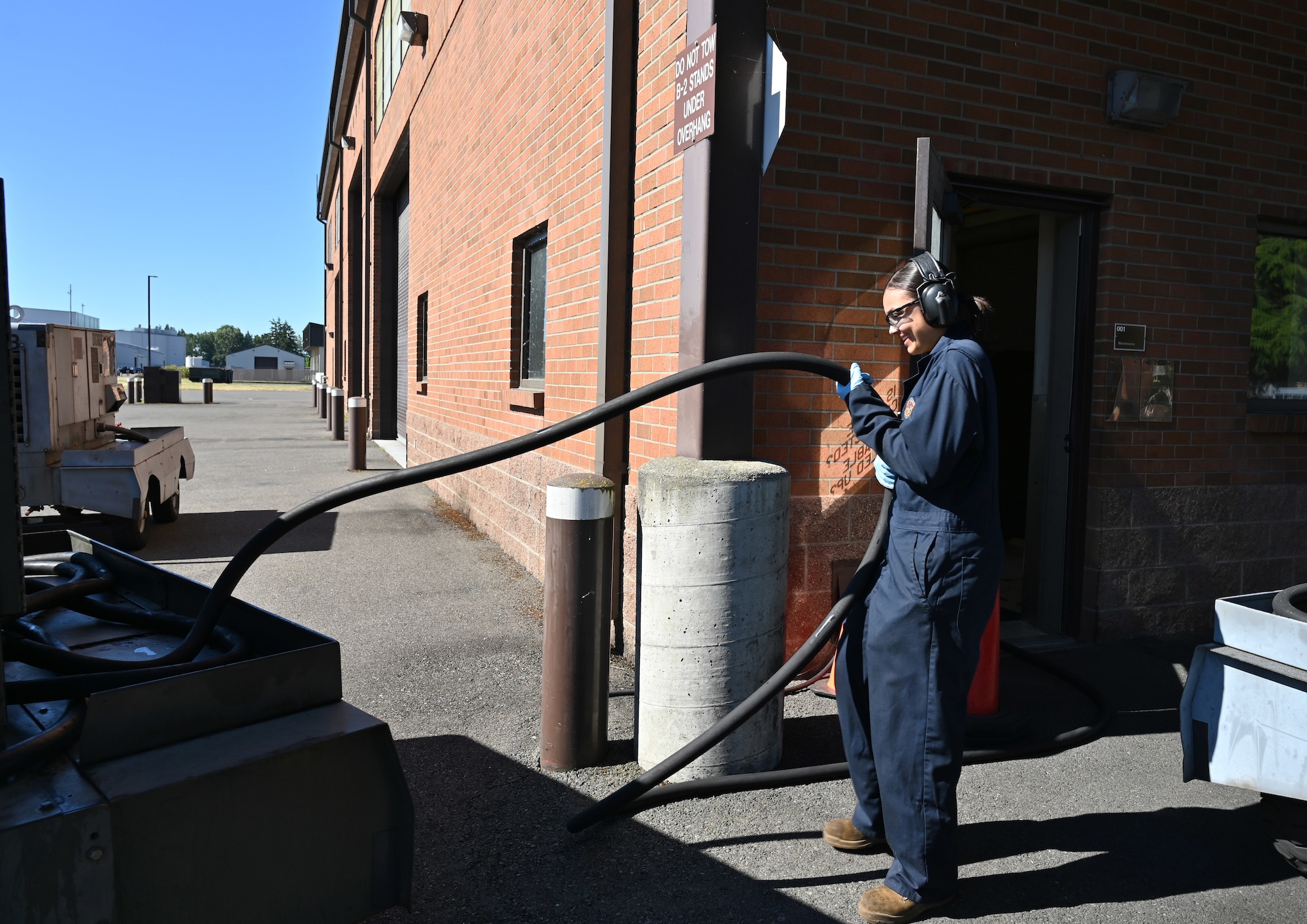 U.S. Air Force Airman 1st Class Viandra Santiago, an aerospace ground equipment journeyman with the 62d Maintenance Squadron, unravels an electrical power cable to plug into the electrical test set at Joint Base Lewis-McChord, Washington, June 25, 2024. AGE Airmen perform load tests to ensure power supply to the aircraft during maintenance. These Airmen play a crucial role in guaranteeing the readiness and operational efficiency of the aircraft by maintaining and servicing essential ground support equipment. (U.S. Air Force photo by Airmen 1st Class Kylee Tyus)