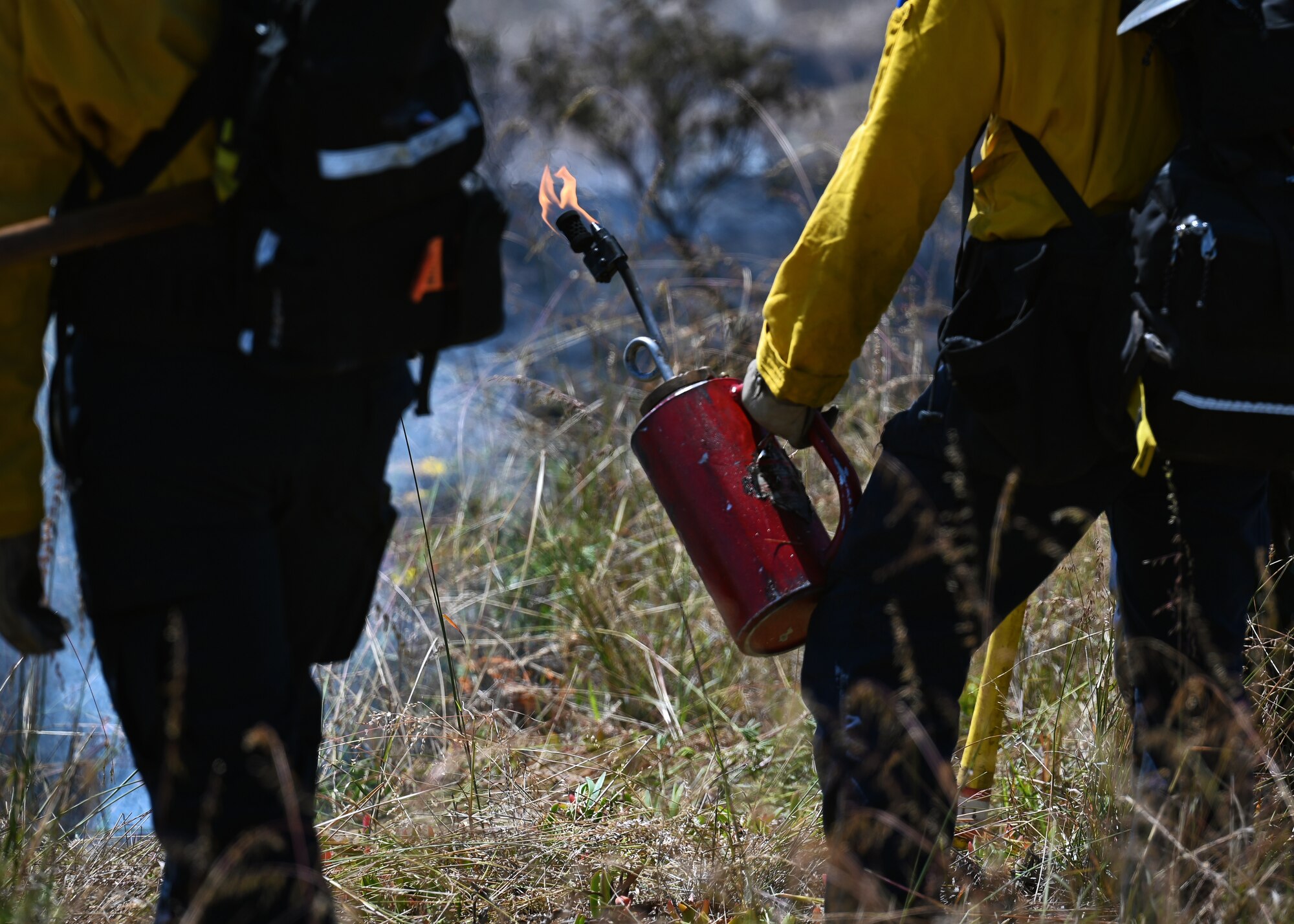 A person holds a fire drip torch.