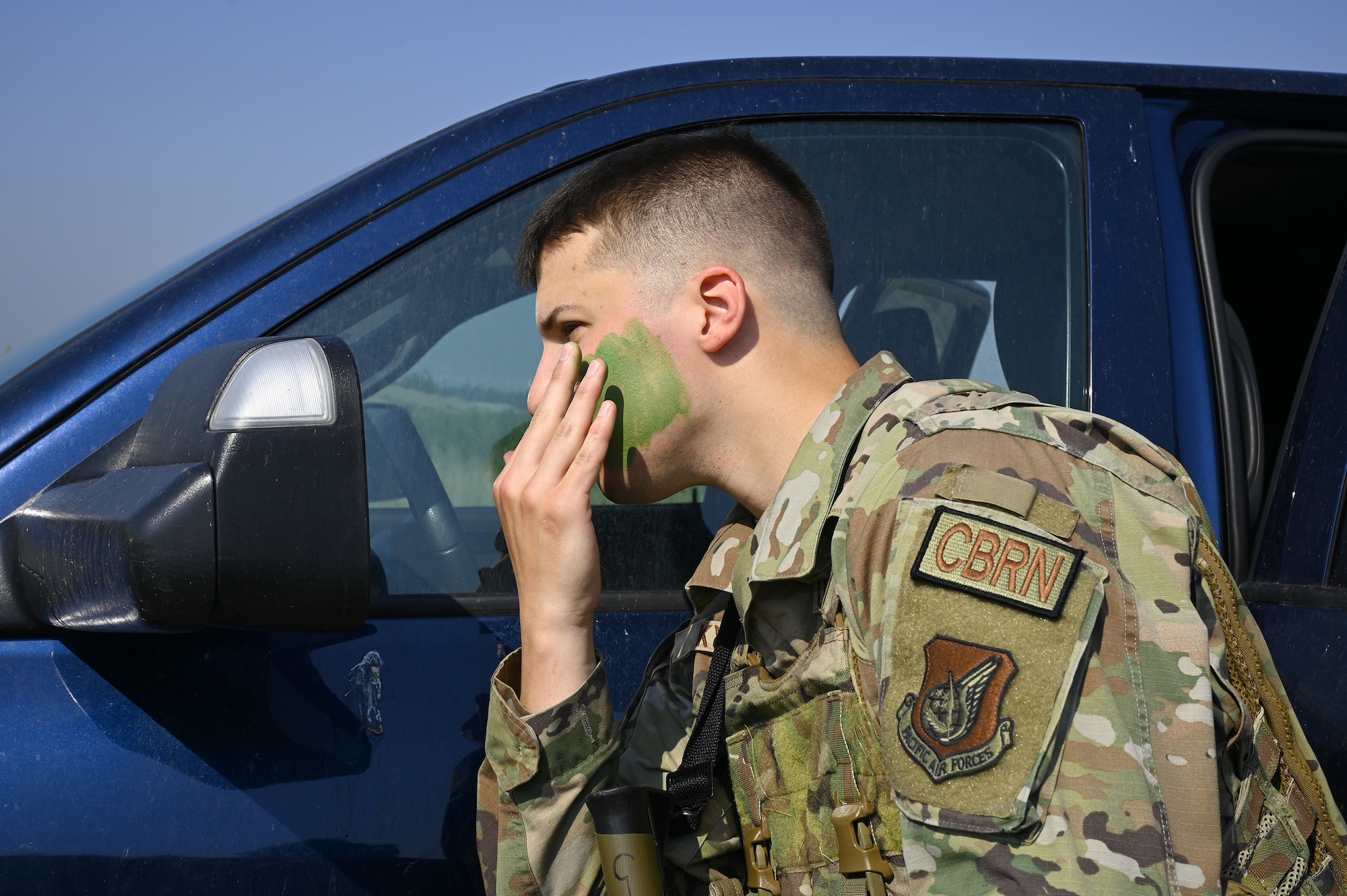 An Airmen from the 354th Civil Engineering Squadron puts on green camouflage paint during the Advanced Ready Training-Core (ART-C) Course June 26, 2024 at Eielson Air Force Base.