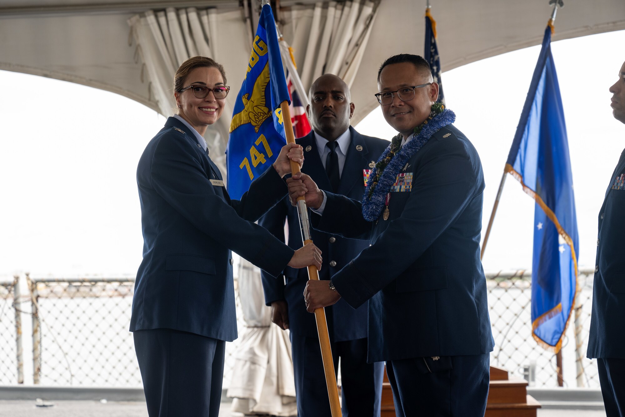 Airmen hold a flag.