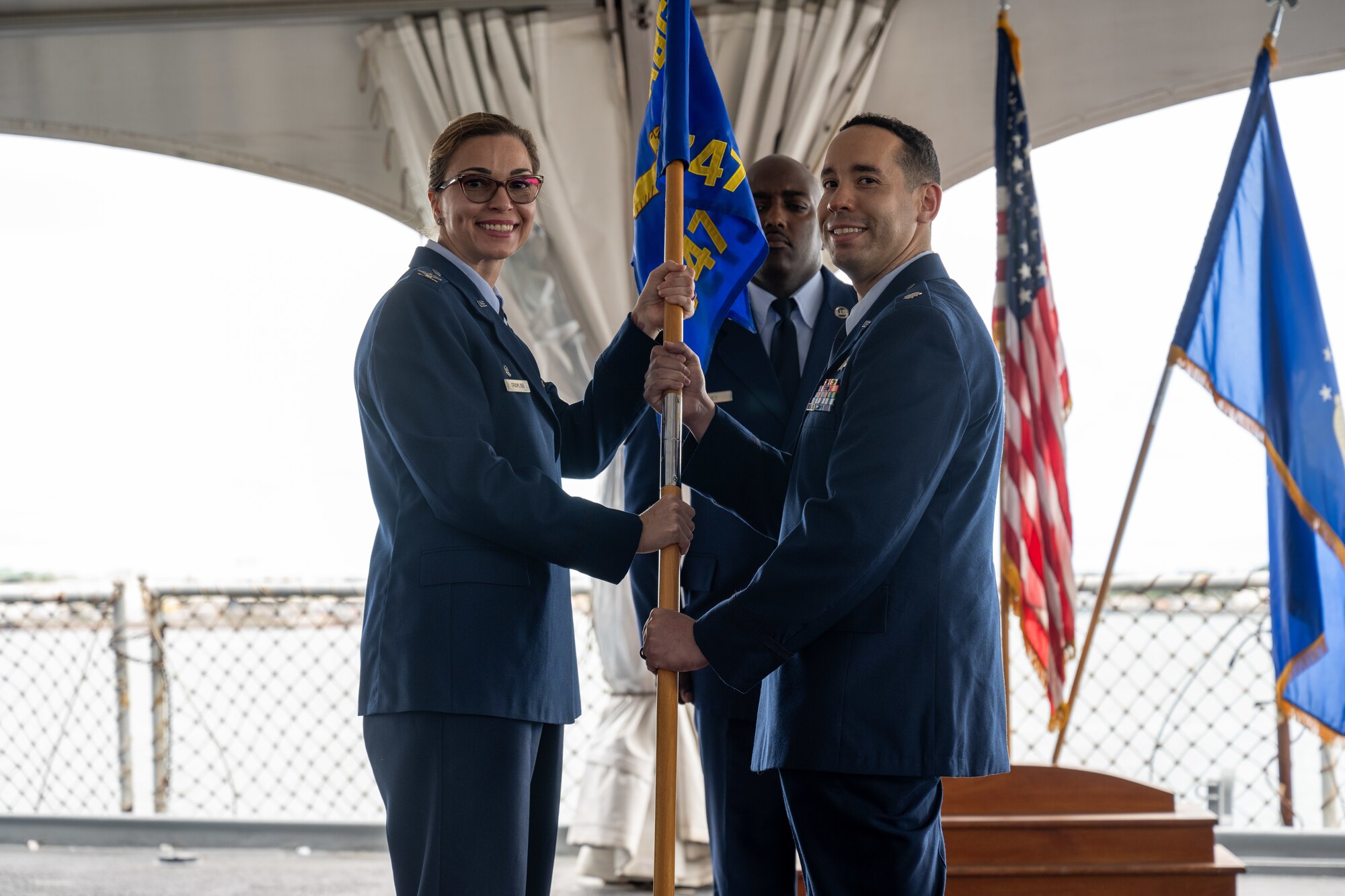 Airmen hold a flag.