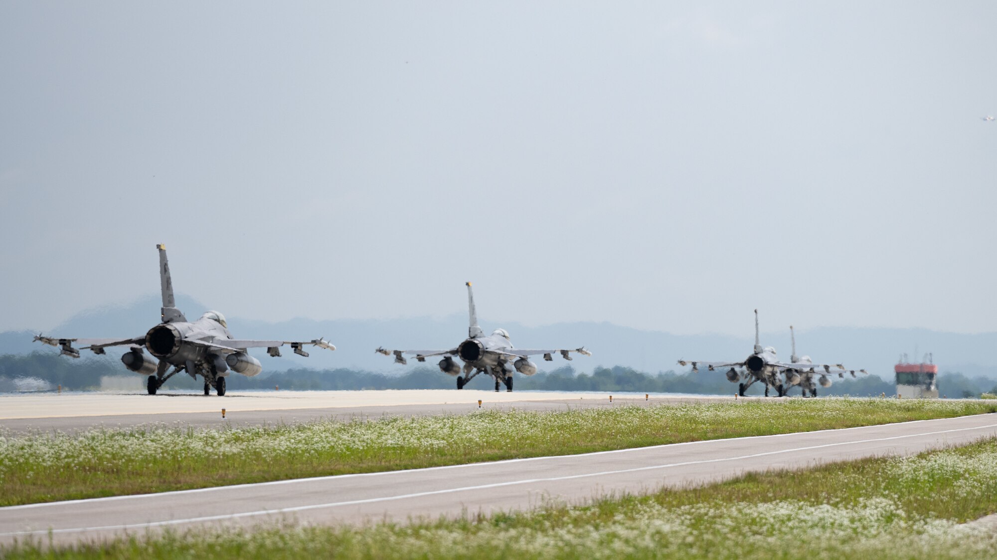 Four F-16 Fighting Falcon aircraft, assigned to the 80th Fighter Squadron, taxi down the flightline for take off as part of Buddy Squadron 24-4.