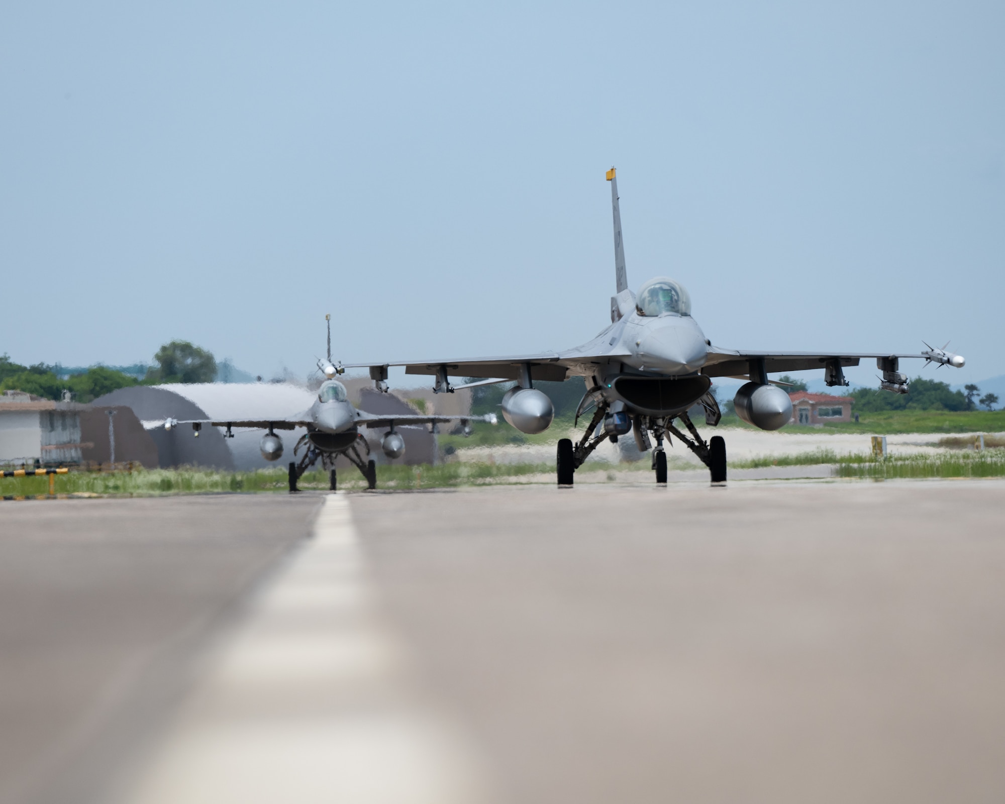 Two F-16 Fighting Falcon aircraft, assigned to the 80th Fighter Squadron, taxi down the flightline during Buddy Squadron 24-4.